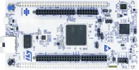 A top view of a microcontroller development board featuring various connectors, buttons, and components. The board's central chip is prominently displayed, alongside labeled pins for input/output functions. The design is primarily white with blue markings for labels and logos.