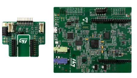 The image displays two green printed circuit boards (PCBs). The larger board includes various electronic components, connectors, and microcontrollers, while the smaller board, positioned on the left, features ports for Grove modules and additional circuitry. Both are labeled prominently with “ST.”