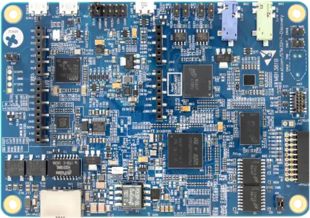 Image of a blue printed circuit board (PCB) featuring various electronic components, including microchips, capacitors, and connectors. The layout includes multiple black chips with labels, along with several ports for connections, indicating it is designed for electronic development or prototyping.