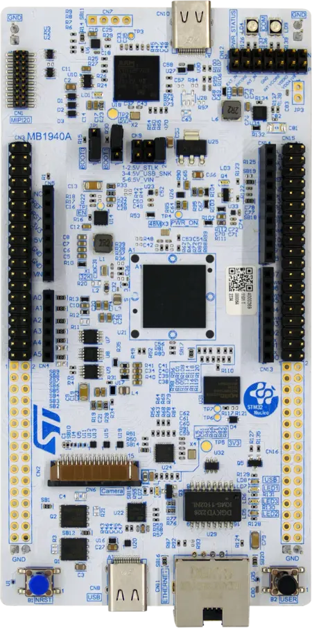 A top-view image of a development board featuring various components such as microcontrollers, connectors, and ports. The board is predominantly blue with printed circuit markings, including power indicators and multiple pin headers for interfacing with other devices.